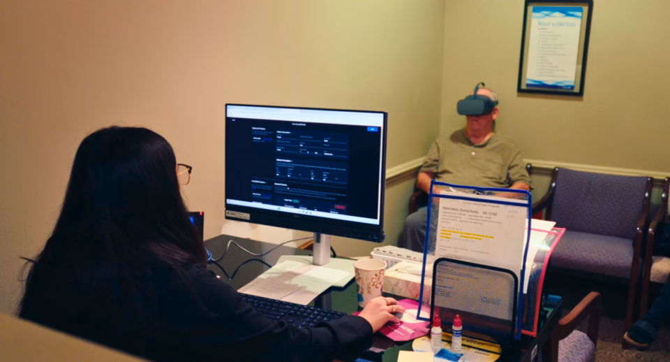 A technician views live results of a patient taking a Carrot visual field test in the waiting room of the eye care clinic.