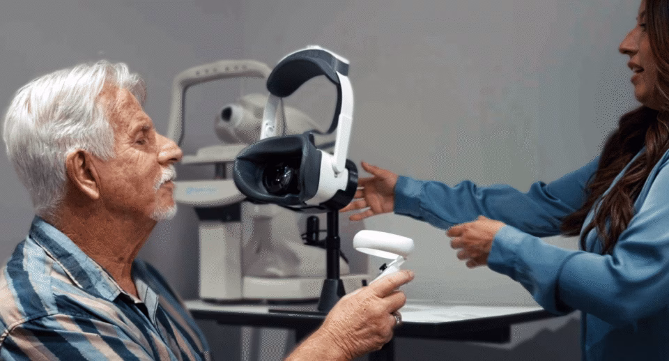 A technician hands a patient a Carrot controller.
