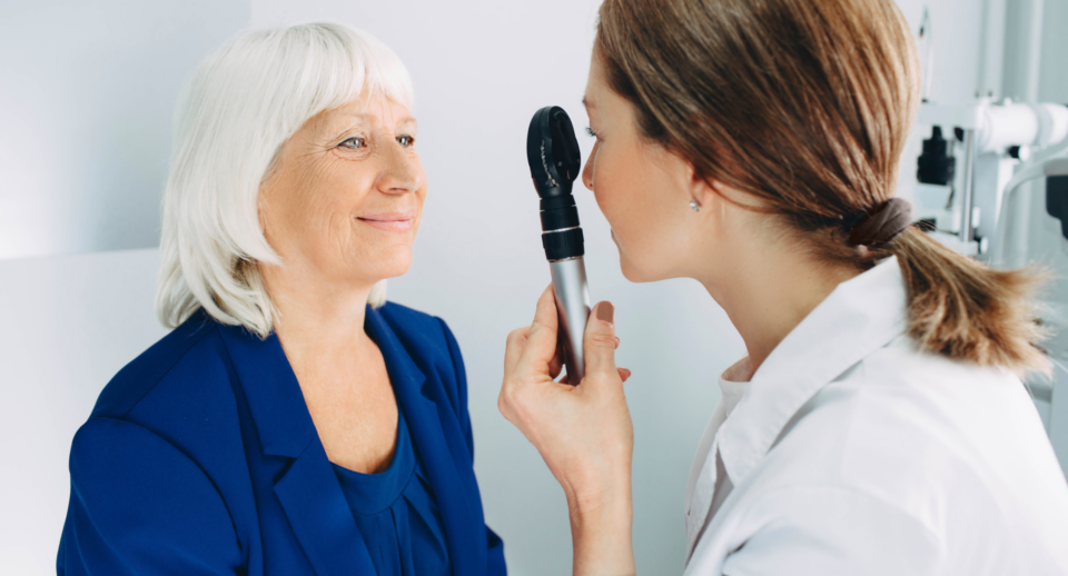 An eye doctor conducts an eye test on a senior woman