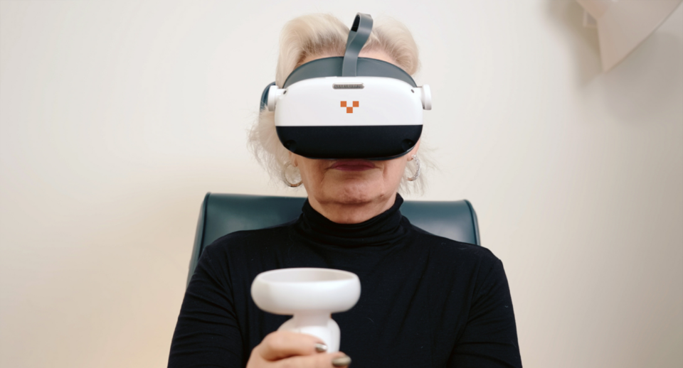 A woman takes a visual field test with a Carrot headset