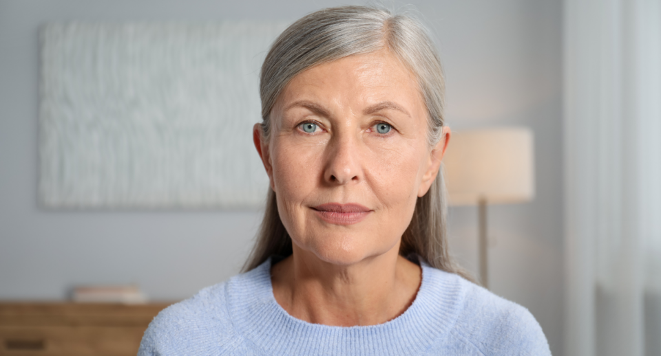 A woman with gray hair and blue eyes